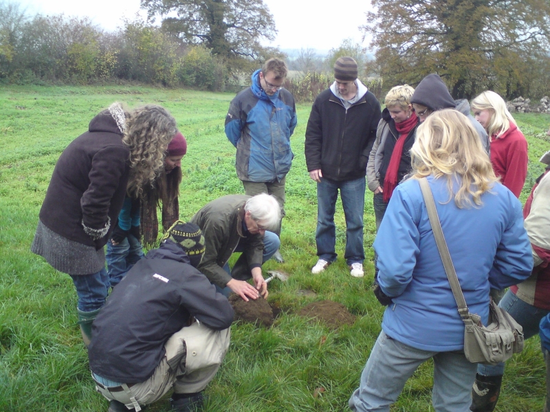 Roger Hitchings looking at soil with a group of young growers