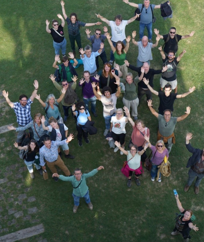 Research partners in a field waving at a drone