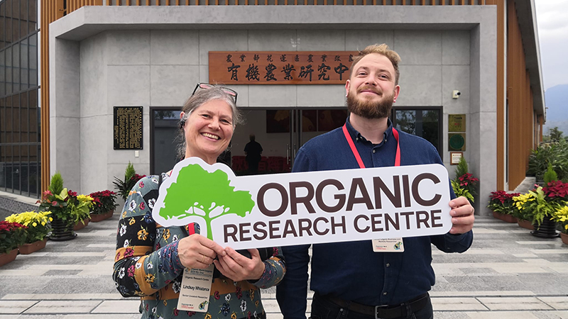 Lindsay and Rowan with ORC logo outside the organic research station in Hualien